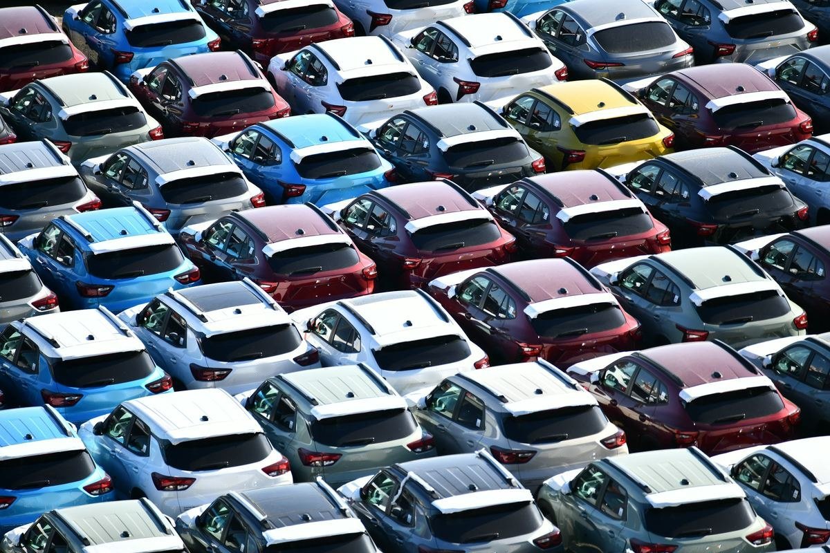 Rijen gekleurde wagens van bovenaf gezien op een grote parking